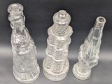 three clear glass bottles sitting next to each other on a table