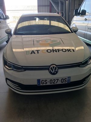 une voiture blanche garée dans un garage à côté d'autres voitures