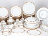 a lot of white and gold plates and bowls on a table