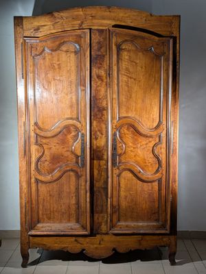 a large wooden cabinet with two doors on top of it
