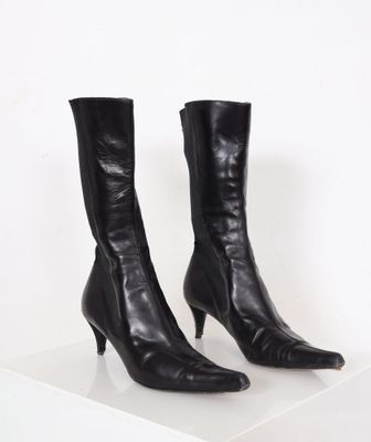 a pair of black leather boots on a white surface