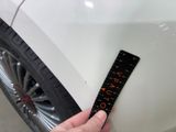 someone is measuring the height of a tire on a white car