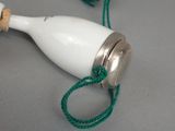 a small white bottle with a green string around it