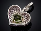 a close up of a heart shaped green tourmaline pendant on a black surface