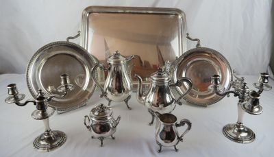 silver plated tea and coffee set on a table with a mirror in the background