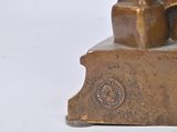 a bronze statue of a man sitting on top of a chair