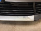 the front end of a silver car with a blue emblem on it