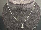 collier en argent avec un pendentif en forme d'étoile, présenté sur un mannequin d'exposition