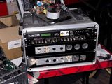 un ordinateur portable posé sur une table, à côté d'une table de mixage