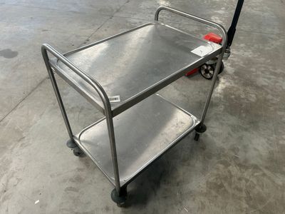 un chariot en métal avec une poignée rouge posé par terre
