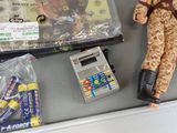a doll, a calculator, and a cell phone on a table