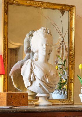 un vase de fleurs et une statue posée sur une commode