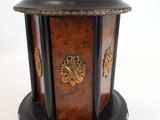 une petite boîte en bois avec un couvercle, posée sur un socle