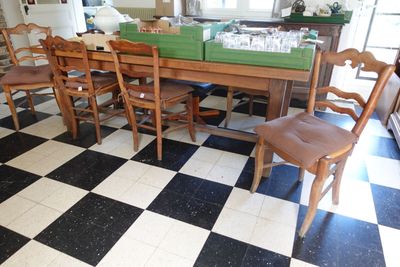une table et des chaises dans une pièce dont le sol est en damier noir et blanc