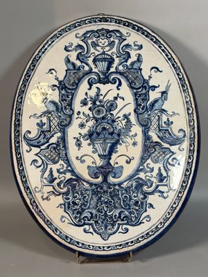une assiette bleue et blanche richement décorée, ornée d'un motif floral