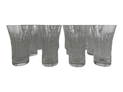four clear glass vases are lined up on a white surface