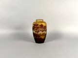 a small vase with a tree on it sitting on a white surface