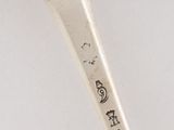 a silver spoon with a handle that has writing on it