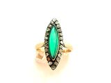 Gros plan sur une bague contenant une pierre verte