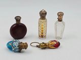quatre petites bouteilles en verre sont alignées sur une surface blanche