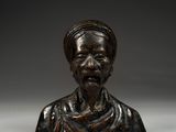 a bronze bust of a man with a turban on his head