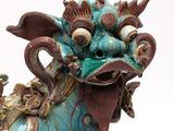 a statue of a dragon sitting on a white surface