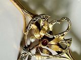 a gold hair pin with a flower and leaves on it