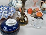 a table with a candle, a vase, a plate, a bowl, and other items on it