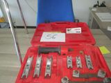 une mallette rouge contenant des outils, posée sur une table