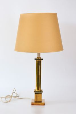 lampe de table en laiton avec un abat-jour beige sur fond blanc
