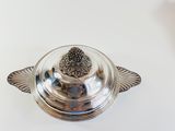 a silver plate with a flower on it on a table