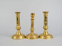 Paire de bougeoirs à poussoir en métal doré de style XIXe.