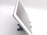 a tablet computer sitting on a stand on a white surface