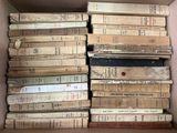 une boîte pleine de vieux livres posée sur le sol