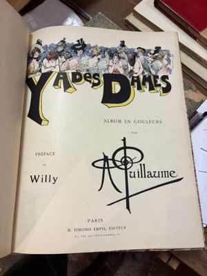 un livre ouvert posé sur une table à côté d'une pile de livres