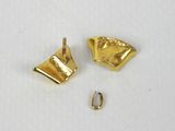 une paire de boucles d'oreilles en or sur une surface blanche