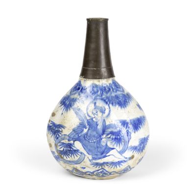 un vieux vase bleu et blanc sur lequel figure l'image d'un homme à cheval