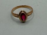 une image d'une bague en or avec une pierre rouge