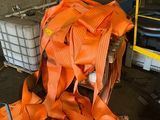 a large pile of orange safety equipment in a room