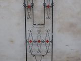 a black iron gate with red flowers on it