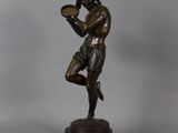 a bronze statue of a man holding a tray