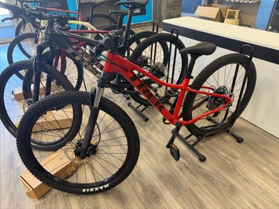 two bikes are parked in a bike shop on a wooden floor