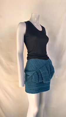 the mannequin is wearing a black top and a blue skirt