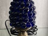 a glass vase with a blue ball on top of it