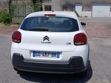 a small white car parked in front of a house