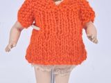 a doll that is wearing an orange dress and hat
