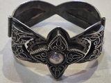silver bracelet with a star design and a crystal center