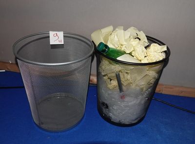 deux poubelles posées l'une à côté de l'autre sur une table bleue