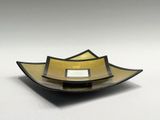 a yellow and black bowl on a white surface