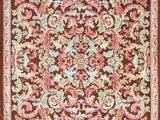 a brown and pink rug with a floral design on it